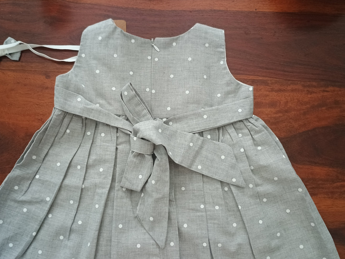 Sleeveless grey white polka frock.