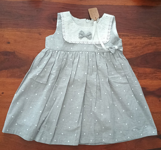 Sleeveless grey white polka frock.