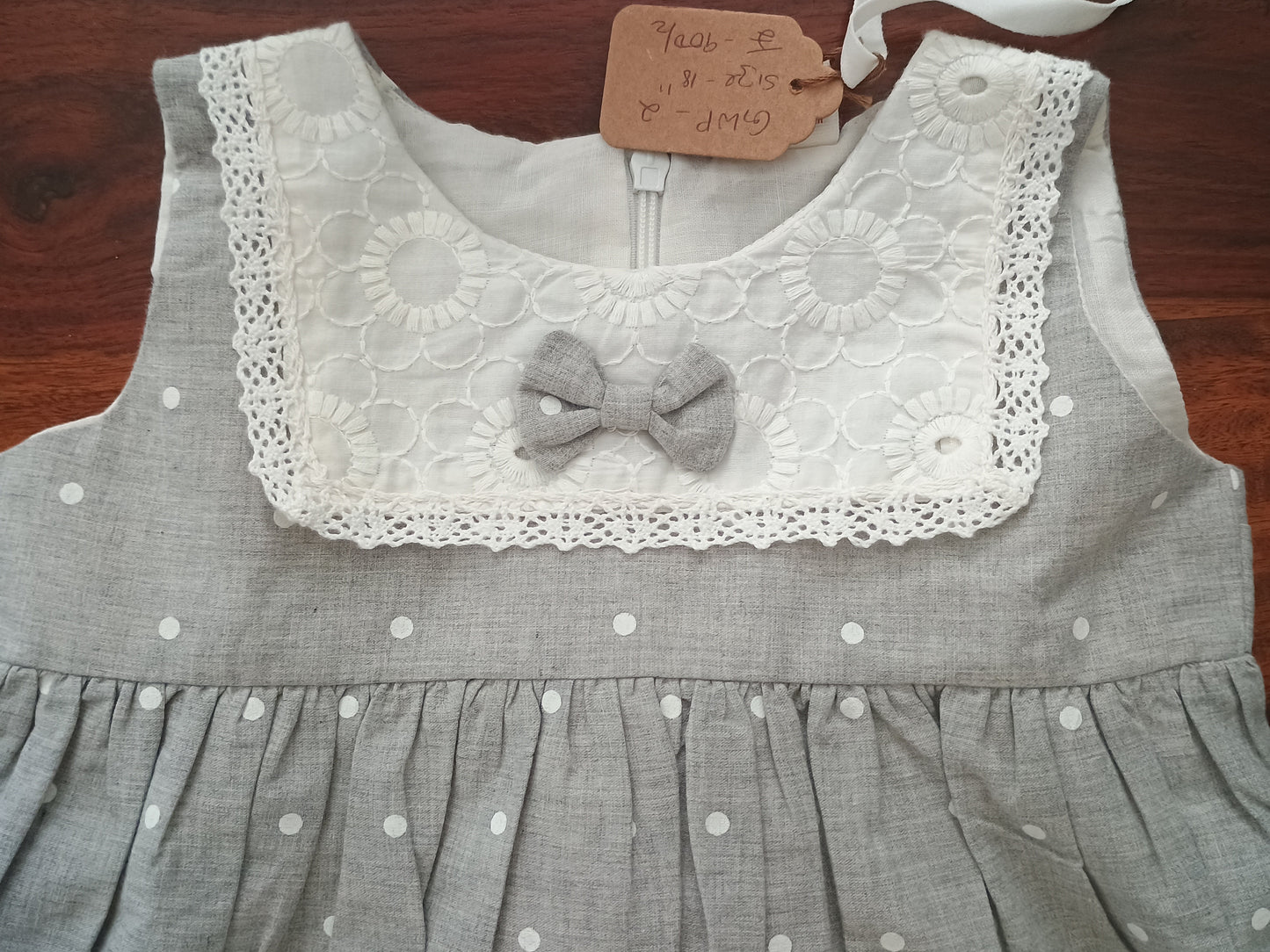 Sleeveless grey white polka frock.